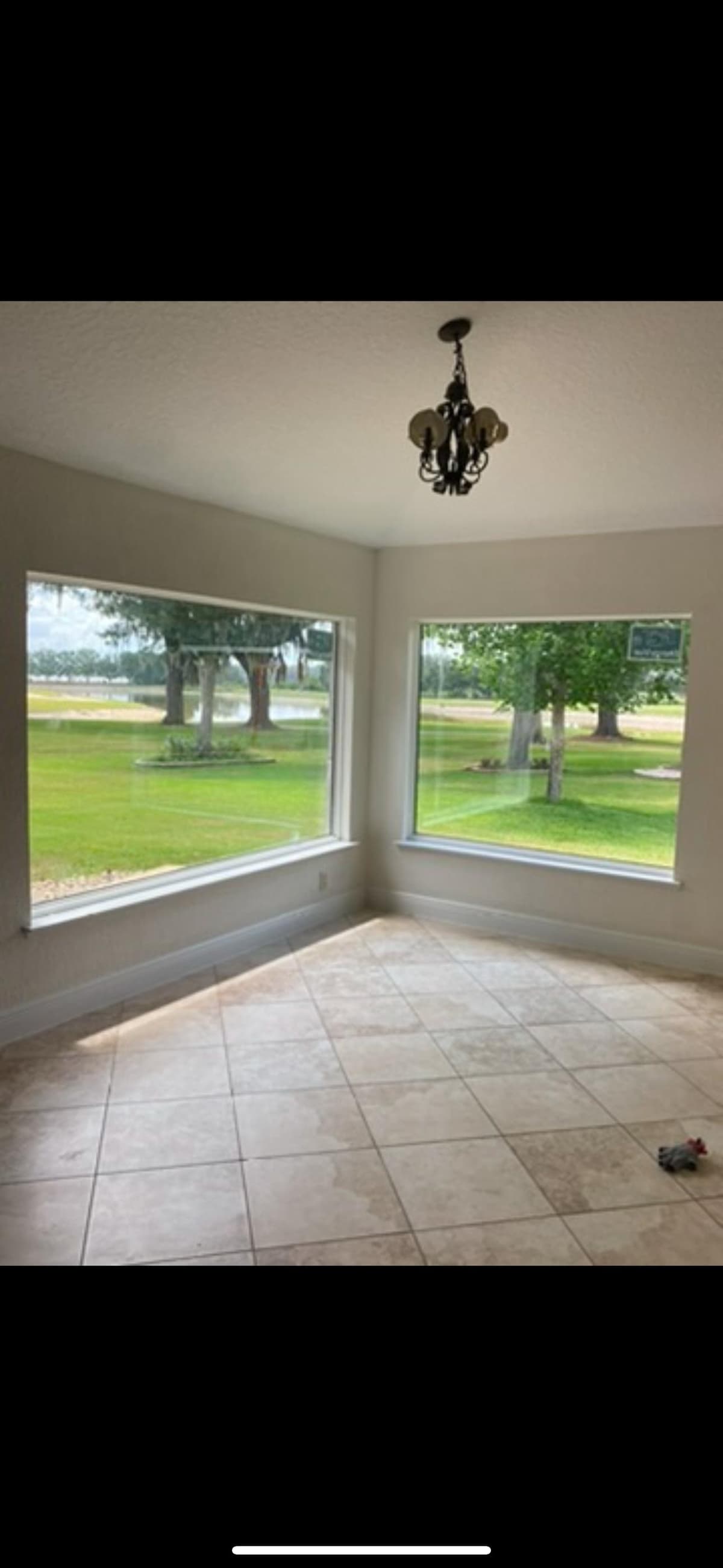 Bright interior room with tile flooring and corner windows